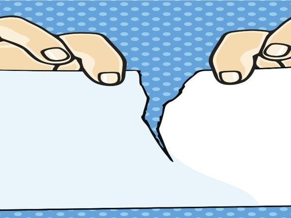 Hands tearing a sheet of paper