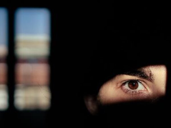A person looking through a dark opening