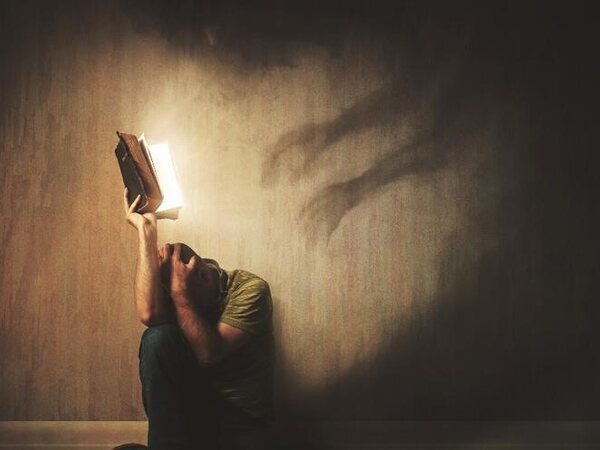 A person reading a Bible in a dark room